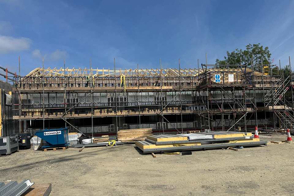 Independent access scaffold along the front of Haverfordia House Wellbeing Centre in Haverfordwest, roof trusses exposed above