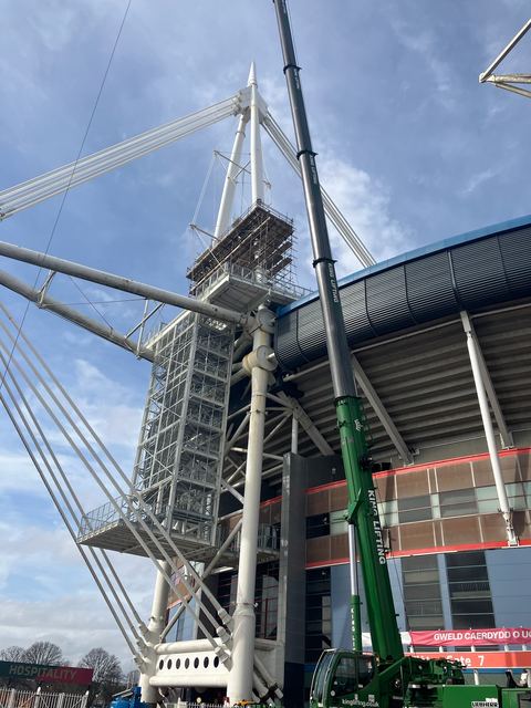 Scaffold around the foot of a Principality Stadium mast, crane alongside